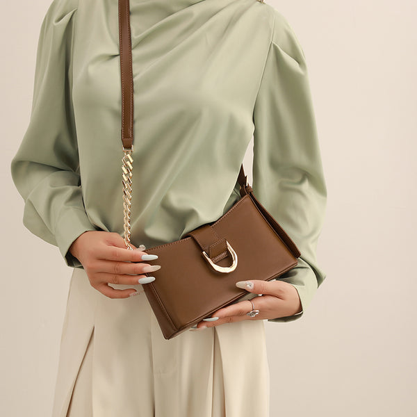 Brown shoulder bag with gold-colored chain and buckle detail