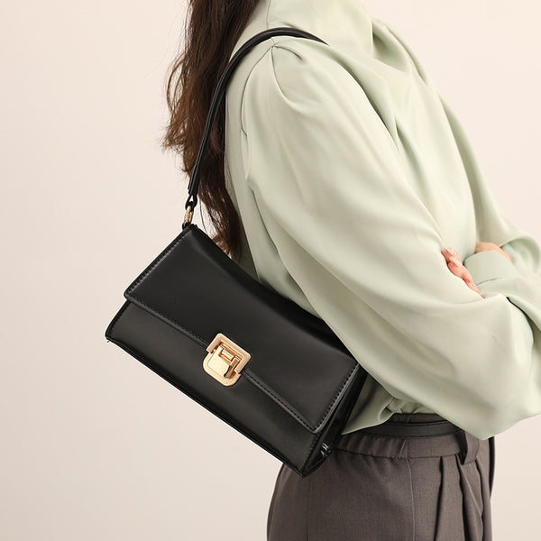 Black shoulder bag with gold-colored buckle – compact and chic